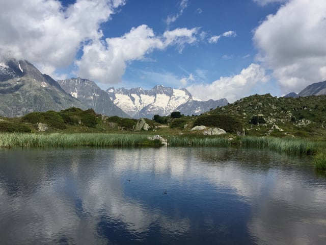 Quellwolken über Bergsee.