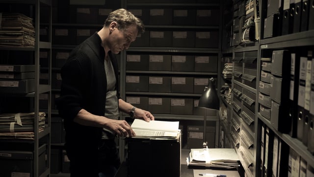 Ein Mann blättert in einem Archiv in einem Buch Ein Mann blättert in einem Archiv in einem Buch