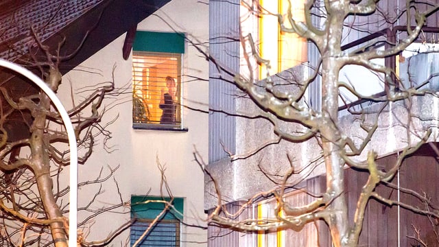 Bild der Fassade des Wohnhauses des «Berner Heiler». Hinter den Jalousien ist eine Frau zu sehen. Bild der Fassade des Wohnhauses des «Berner Heiler». Hinter den Jalousien ist eine Frau zu sehen.