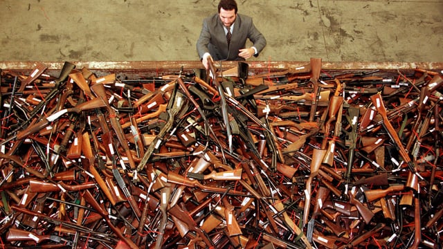 Ein Polizist aus Sydney blickt auf einen Berg Waffen, die 1997 im Zuge des neuen Gesetzes zurückgegeben wurden. Ein Polizist aus Sydney blickt auf einen Berg Waffen, die 1997 im Zuge des neuen Gesetzes zurückgegeben wurden.