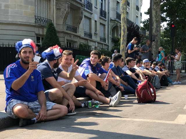 Gruppe auf dem Trottoirrand sitzend.