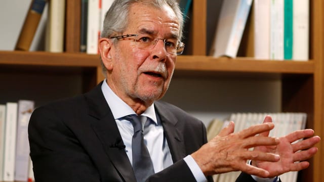 Van der Bellen vor Büchergestell sitzend und sprechend Van der Bellen vor Büchergestell sitzend und sprechend