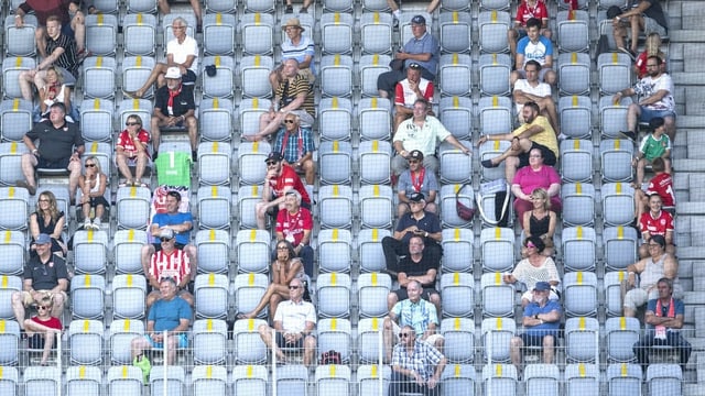Sitzende Zuschauer mit Abstand in einem Stadion Sitzende Zuschauer mit Abstand in einem Stadion