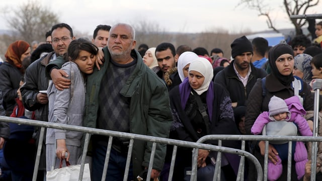 Flüchtlinge hinter einer Absperrung Flüchtlinge hinter einer Absperrung