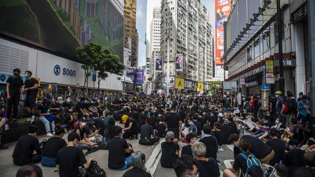 Menschen sitzen auf einer Strasse in Hongkong. Menschen sitzen auf einer Strasse in Hongkong.