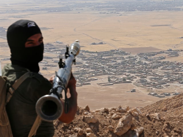 Kurdischer Kämpfer blickt auf Stadt südlich von Erbil (2014) Kurdischer Kämpfer blickt auf Stadt südlich von Erbil (2014)
