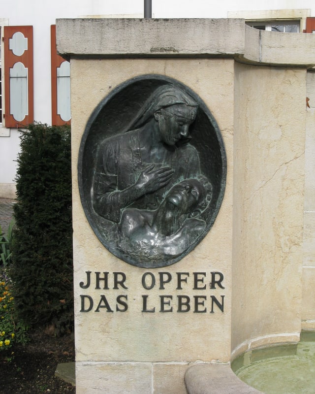 Eine Rotkreuzschwester, die einen leidenden Soldaten hält, ist in Stein gemeisselt. Eine Rotkreuzschwester, die einen leidenden Soldaten hält, ist in Stein gemeisselt.