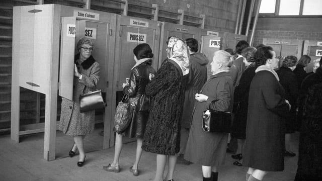 Frauen geben ihre Stimme in einer Wahlkabine ab