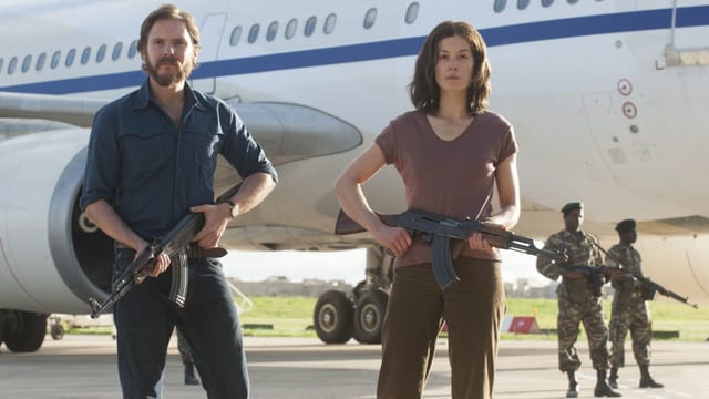 Daniel Brühl posiert mit der falschen Deutschen (Rosamund Pike) vor dem entführten Flugzeug. Daniel Brühl posiert mit der falschen Deutschen (Rosamund Pike) vor dem entführten Flugzeug.