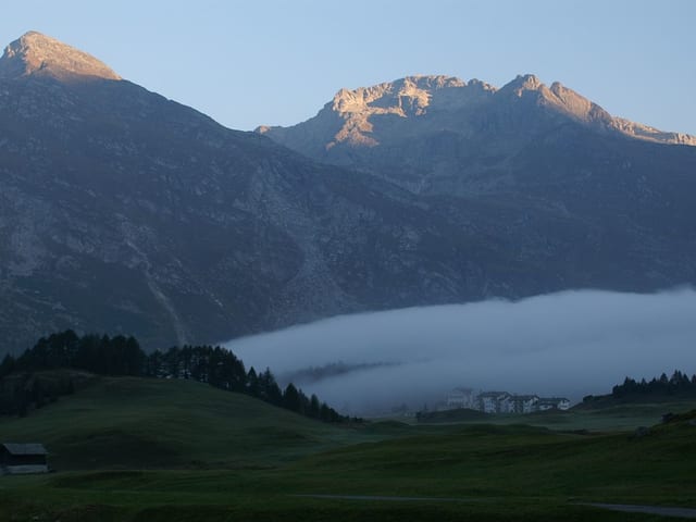 Blick über das Oberengadin. Im Hintergrund zwei Berge, in der Mitte über dem Tal ein wurstförmiges Wolkengebilde. Blick über das Oberengadin. Im Hintergrund zwei Berge, in der Mitte über dem Tal ein wurstförmiges Wolkengebilde.