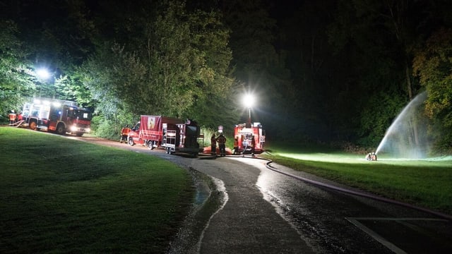 Feuerwehrautos bei Nacht. Daneben eine Wasserspritze. Feuerwehrautos bei Nacht. Daneben eine Wasserspritze.