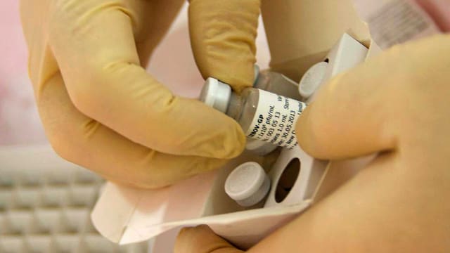 Laborant hält Impstoff-Ampullen Laborant hält Impstoff-Ampullen