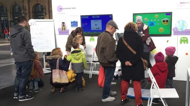 Kinder und Erwachsene an einem der Infostände Kinder und Erwachsene an einem der Infostände