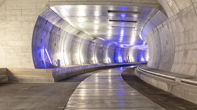 Der Blick in einen Tunnel, der eine rechtskurve macht. Viel glänzender Beton und blauer Schimmer an den Wänden. Der Blick in einen Tunnel, der eine rechtskurve macht. Viel glänzender Beton und blauer Schimmer an den Wänden.