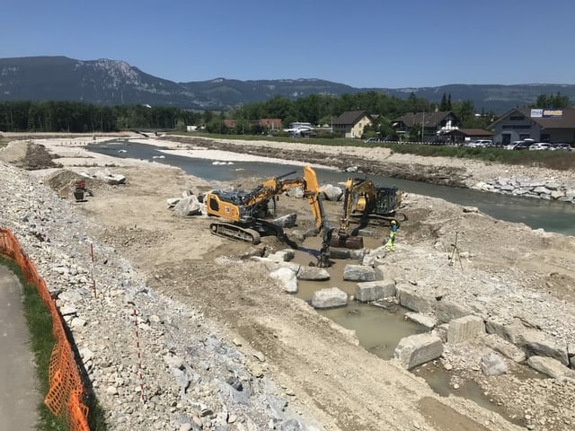 Bagger und Lastwagen auf Kiesbank im Fluss. Bagger und Lastwagen auf Kiesbank im Fluss.
