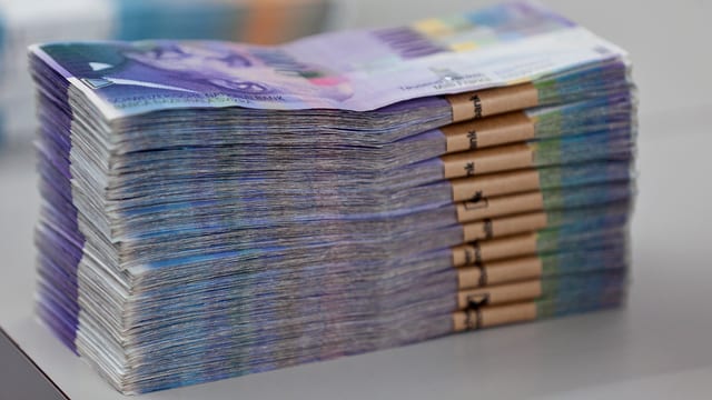 Bündel von Tausender-Banknoten auf einem Tisch Bündel von Tausender-Banknoten auf einem Tisch