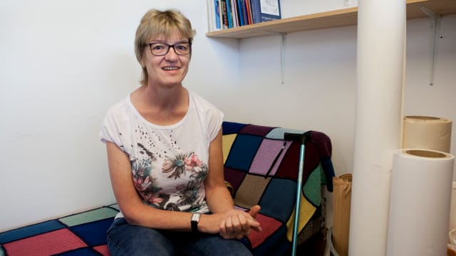 Eine Frau sitzt auf einem Sofa. Eine Frau sitzt auf einem Sofa.