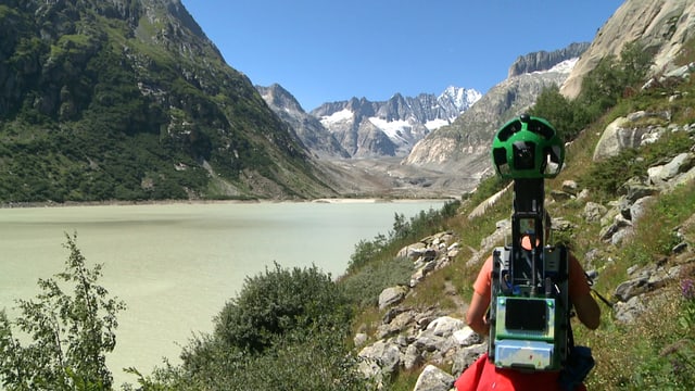 Mann, der eine Google-Street-View-Kamera am Rücken trägt. Mann, der eine Google-Street-View-Kamera am Rücken trägt.