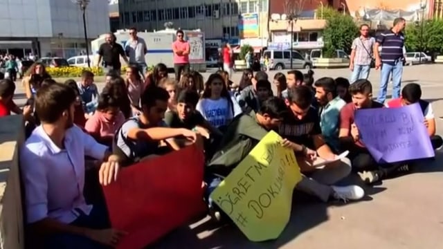 Protestierende Schüler mit Transparenten sitzen am Boden. Protestierende Schüler mit Transparenten sitzen am Boden.
