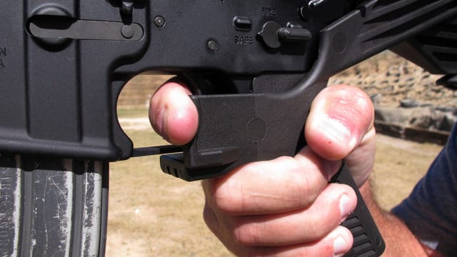 Eine Hand an einer Waffe mit Bump Stocks. Eine Hand an einer Waffe mit Bump Stocks.