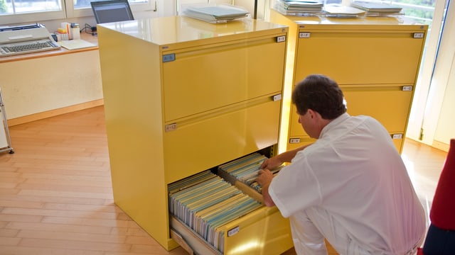 Arzt am Aktenschrank. Arzt am Aktenschrank.