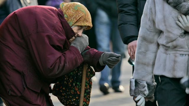 Alte Frau streckt ihre Hand für eine Spende aus. Alte Frau streckt ihre Hand für eine Spende aus.