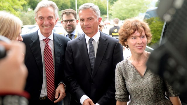 Drei Personen in einer Reihe vor den Fotografen stehend. Drei Personen in einer Reihe vor den Fotografen stehend.
