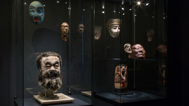 Vitrine mit Masken und einem dreidimensionalen Kopf des Künstlers Ai Weiwei. Vitrine mit Masken und einem dreidimensionalen Kopf des Künstlers Ai Weiwei.