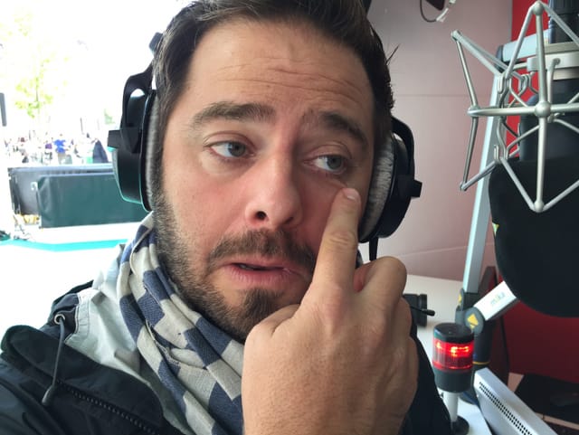 Marco Thomann reibt seinen Finger an der Schnittfläche der Zwiebel und massiert die Flüssigkeit unterhalb den Augen ein.
