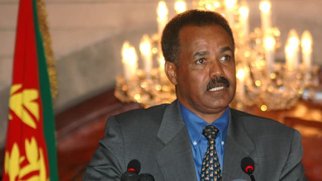 Der eritreische Staatspräsident Isayas Afewerki sitzt hinter Mikrofonen neben einer Fahne. Der eritreische Staatspräsident Isayas Afewerki sitzt hinter Mikrofonen neben einer Fahne.