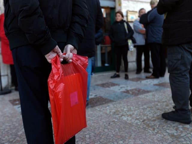 Bedürftige stehen Schlange vor einem Postbüro Bedürftige stehen Schlange vor einem Postbüro