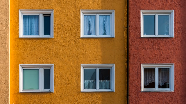 Blick auf eine gelbe Hauswand eines Wohnblocks. Zwei Stockwerke und 6 Fenster sind sichtbar. Blick auf eine gelbe Hauswand eines Wohnblocks. Zwei Stockwerke und 6 Fenster sind sichtbar.