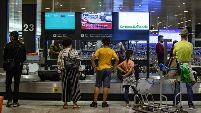 Passagiere warten beim Gepäckband am Flughafen Passagiere warten beim Gepäckband am Flughafen