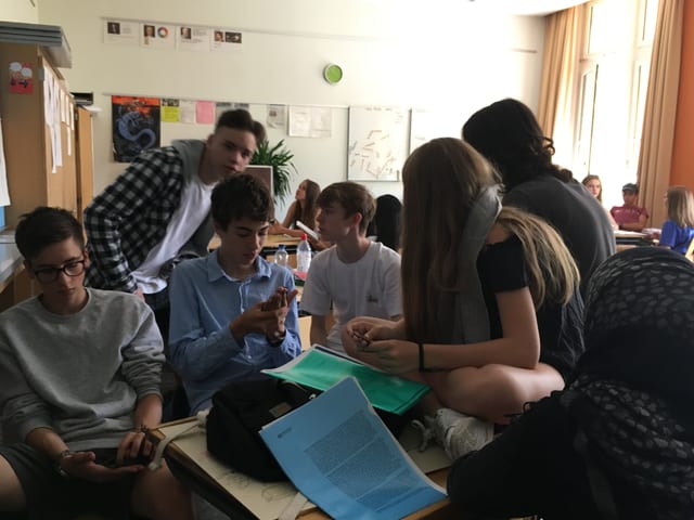 Eine Gruppe Jugendlicher um einen Tisch Eine Gruppe Jugendlicher um einen Tisch