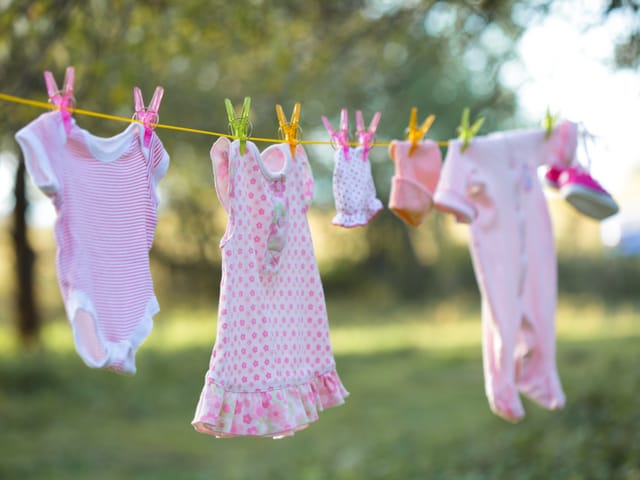 Kinderkleider an der Wäscheleine.