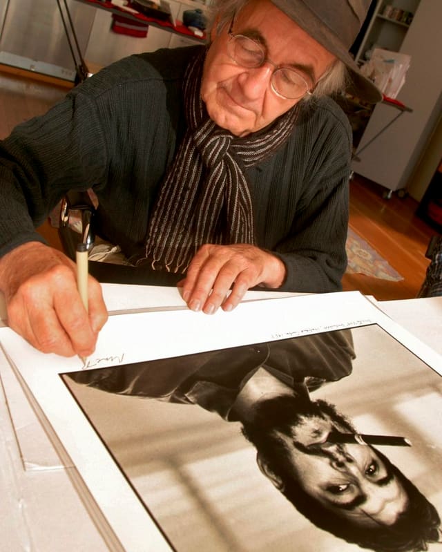 René Burri signiert sein berühmtes Che-Bild.