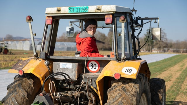 ein junger Mann fährt einen Traktor ein junger Mann fährt einen Traktor
