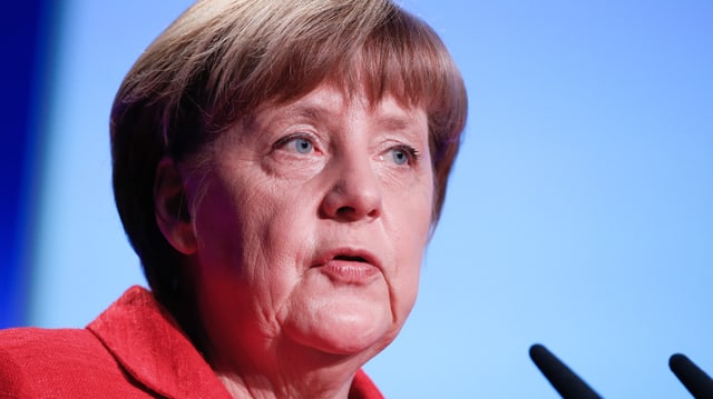 Angela Merkel in rotem Kleid in Grossaunfahme vor Mikrofonen Angela Merkel in rotem Kleid in Grossaunfahme vor Mikrofonen