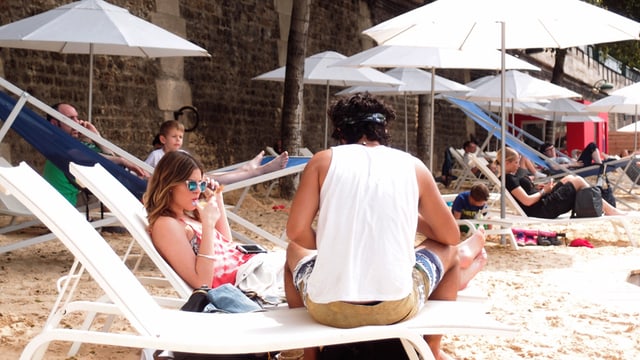 Ein Paar sitzt auf Liegestühlen am Strand. Ein Paar sitzt auf Liegestühlen am Strand.