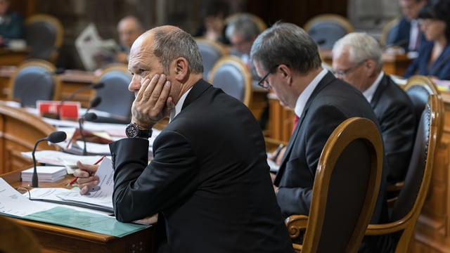 Mann sitzt und stützt seinen Kopf in die Hand. Mann sitzt und stützt seinen Kopf in die Hand.