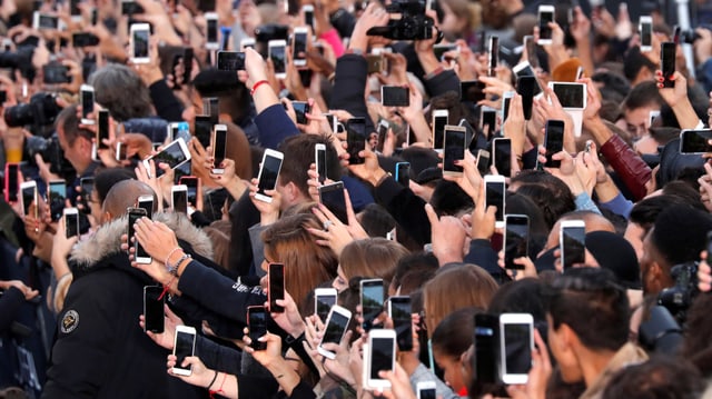 Dutzende Smartphones werden von Zuschauern in die Höhe gstreckt. Dutzende Smartphones werden von Zuschauern in die Höhe gstreckt.
