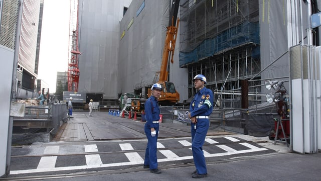 Arbeiter vor einem Geschäftsgebäude Arbeiter vor einem Geschäftsgebäude