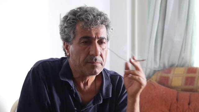 Taha Khalil sitzt rauchend an einem Tisch Taha Khalil sitzt rauchend an einem Tisch