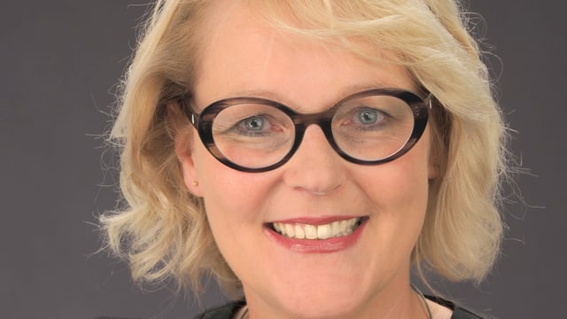 Eine Frau lächelt in die Kamera. Eine Frau lächelt in die Kamera.