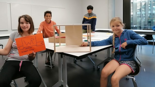 Zwei Mädchen und zwei Knaben an einem Tisch Zwei Mädchen und zwei Knaben an einem Tisch