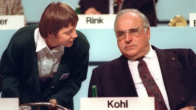 Merkel beugt sich zu Helmut Kohl. Merkel beugt sich zu Helmut Kohl.
