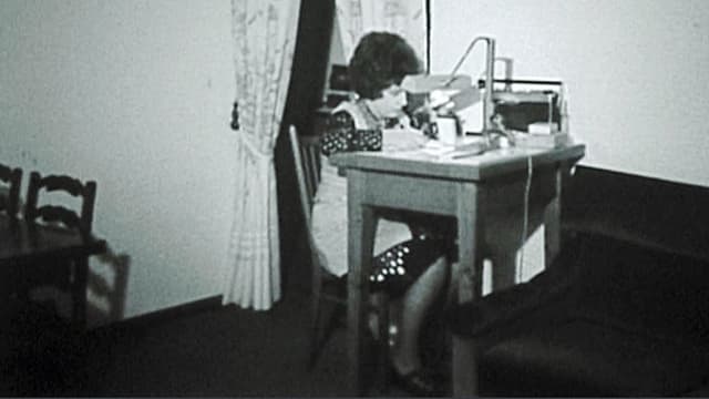 Schwarz-weiss-Aufnahme einer Arbeiterin an einem Tischchen. Schwarz-weiss-Aufnahme einer Arbeiterin an einem Tischchen.
