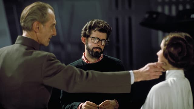 Ein Regisseur und zwei Schauspieler am Filmset Ein Regisseur und zwei Schauspieler am Filmset