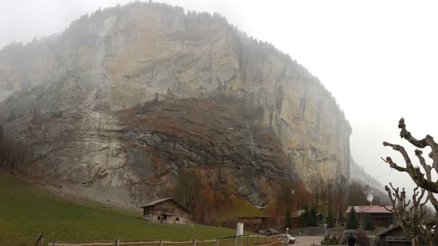 Felswand mit Bauernhäusern im Vordergrund Felswand mit Bauernhäusern im Vordergrund