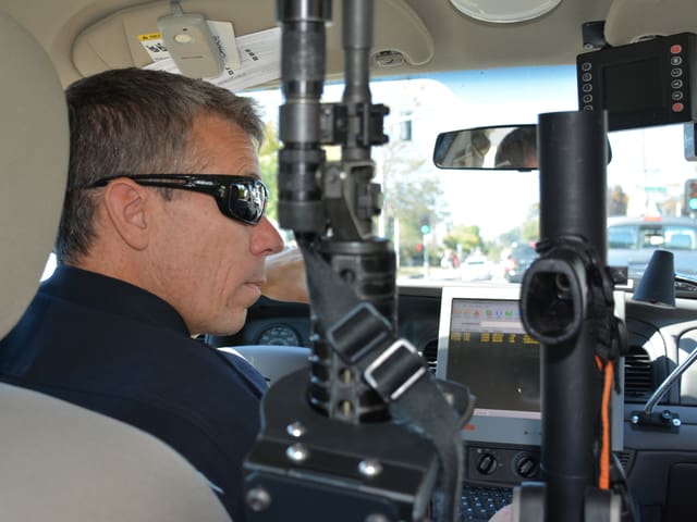 Brent Northrup sitzt mit dunkler Sonnenbrille im Auto, neben ihm sieht man seine beiden Gewehre. Brent Northrup sitzt mit dunkler Sonnenbrille im Auto, neben ihm sieht man seine beiden Gewehre.